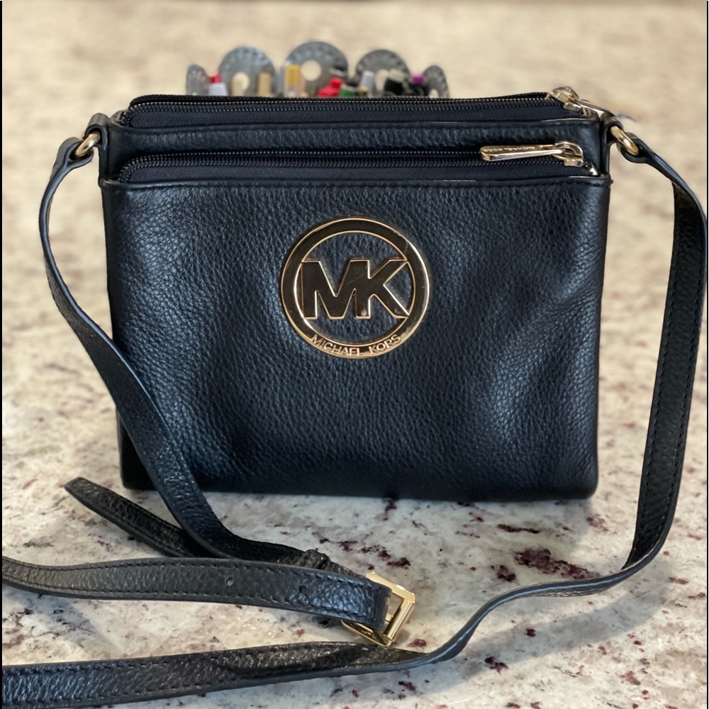 Michael Kors soft leather, back, smaller crossbody style purse gold detail.